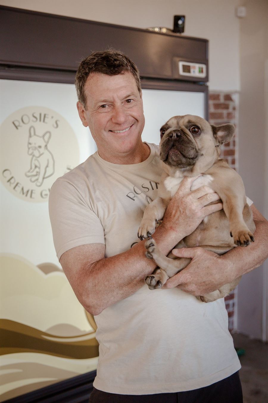 Steve Longman, owner of Rosie's Ice Cream, holding Rosie the French Bulldog